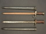 four different types of swords are displayed on a table