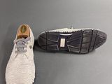 pair of white knitted shoes on a gray surface