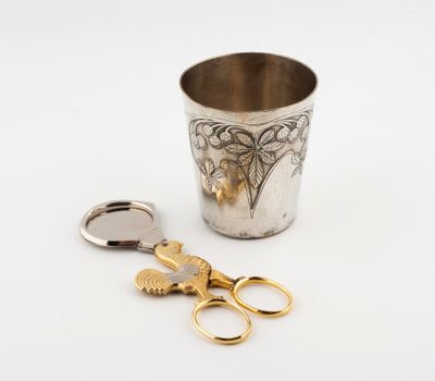 une coupe en argent avec une paire de ciseaux à côté