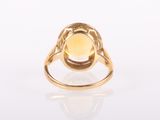 a gold ring with a yellow stone in the center