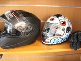 two helmets and gloves on a shelf in a room