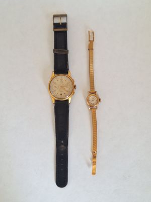 an image of a couple of watches sitting on top of a white surface