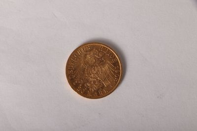 une pièce d'or sur une surface blanche avec un fond blanc