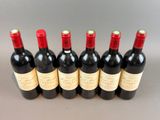 six bottles of red wine lined up in a row
