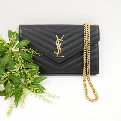 a black saint laurent wallet bag with a gold chain