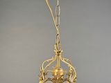 an antique brass hanging light fixture with a glass shade