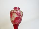 un vase rouge orné d'un motif floral, posé sur une table
