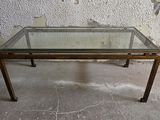 une table en verre avec un cadre en métal et un plateau en verre