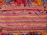 a close up of a colorful rug on a wooden floor