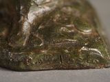 a bronze statue of a dog sitting on a rock