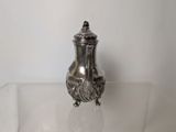 a silver vase sitting on a clear glass table