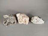 three different types of rocks on a gray surface