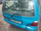 a small blue car parked on the side of the road