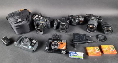 de nombreux appareils photo et accessoires de toutes sortes disposés sur la table