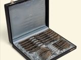 a black case with silverware in it on a white surface