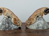 pair of ceramic figurines of a monkey on a rock on a wooden table