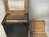 une vieille machine à écrire posée à côté d'une boîte remplie de vieilles machines à écrire