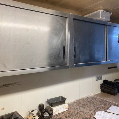 une cuisine avec des placards en inox et des plans de travail en granit