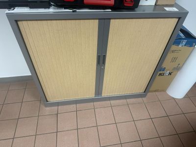 une petite armoire à deux portes, surmontée d'une borne d'incendie rouge