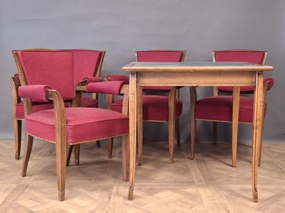 four chairs and a table in a room with a grey wall