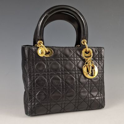 a black handbag with gold hardware on the handle