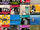Divers disques de jazz sont exposés sur un mur dans une pièce