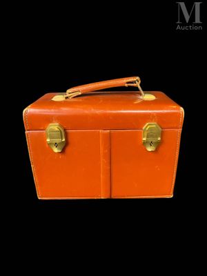 une valise orange posée sur une surface noire