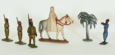 many figurines of different people on a white surface