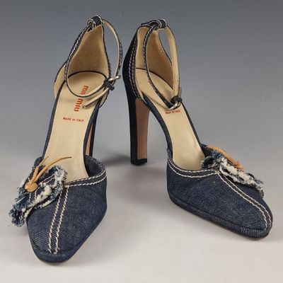 pair of women ' s denim heels with a bow on the heel