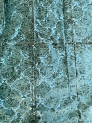 a close up view of a bed with a blue comforter on it