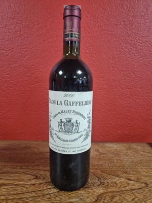 une bouteille de vin rouge posée sur une table en bois