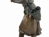 bronze statue of a woman with a basket and a broom