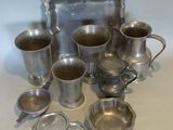 many silver cups and trays sitting on a table