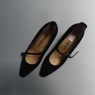 une paire de chaussures noires posée sur une surface blanche