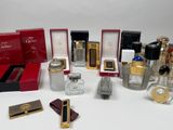 plusieurs flacons de parfum et boîtes de différentes sortes posés sur une surface blanche
