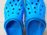 a pair of blue children ' s crocs on a white background