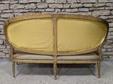 a couch with a yellow cover on it in front of a brick wall