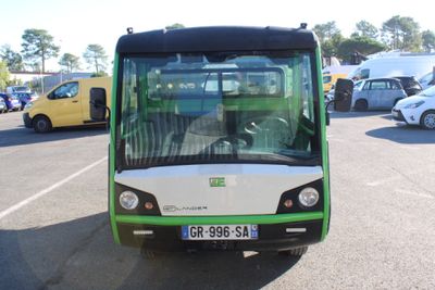 a green and white bus that is parked in a parking lot