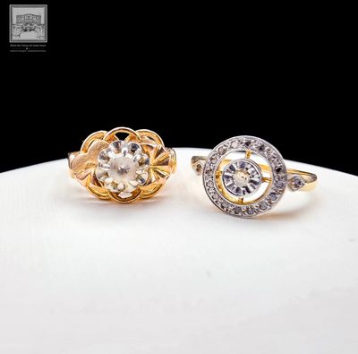 two gold and silver rings with diamonds on a white surface
