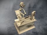 a metal sculpture of a man sitting at a desk with a computer