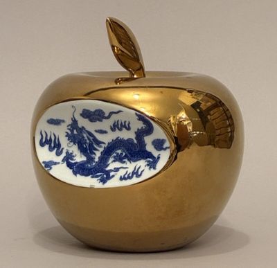 a gold apple with a blue dragon on it