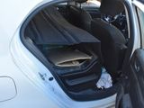 a white car with its door open and a bag in the passenger seat