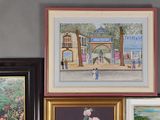 de nombreux tableaux accrochés au mur au-dessus d'une étagère