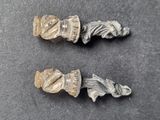 two pieces of silver colored metal on top of a black surface