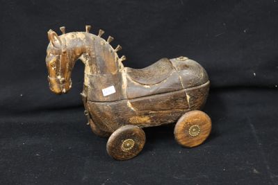a wooden toy horse that is sitting on a black background