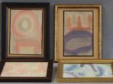 trois tableaux encadrés, de couleurs et de formes différentes, posés sur une table