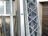 a pile of metal poles and ladders in front of a building