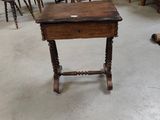 a small table with a drawer on it in the middle of a room