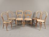 four chairs are lined up in a row against a gray wall
