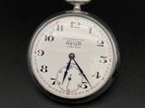 a close up of a pocket watch on a black surface